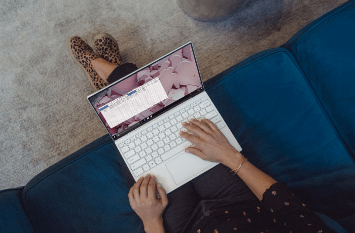 A woman checks a spreadsheet while sitting at home