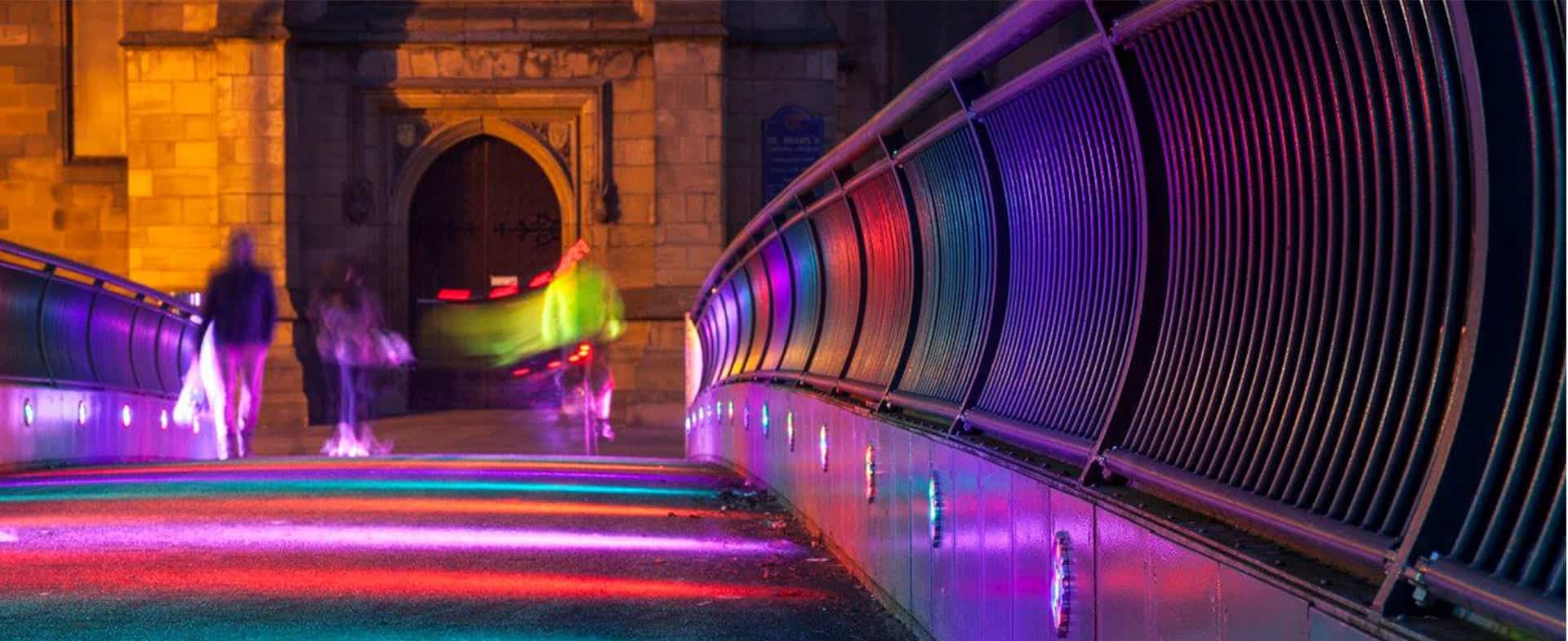 A walkway highlighted with multi-coloured lighting.