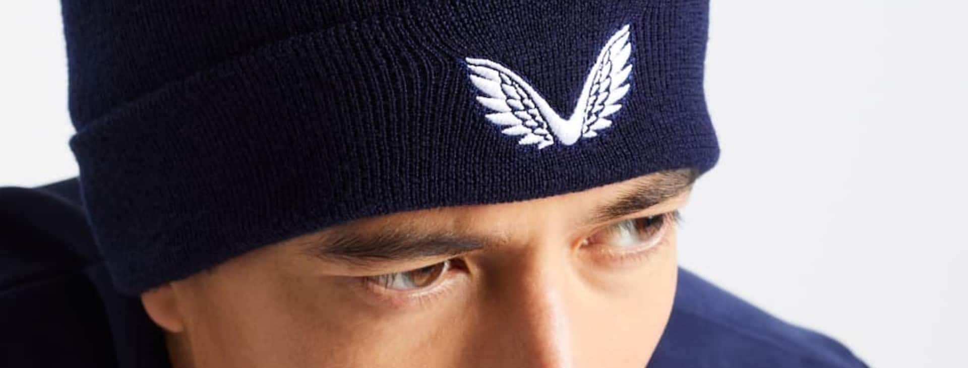 model wears blue Castore beanie hat